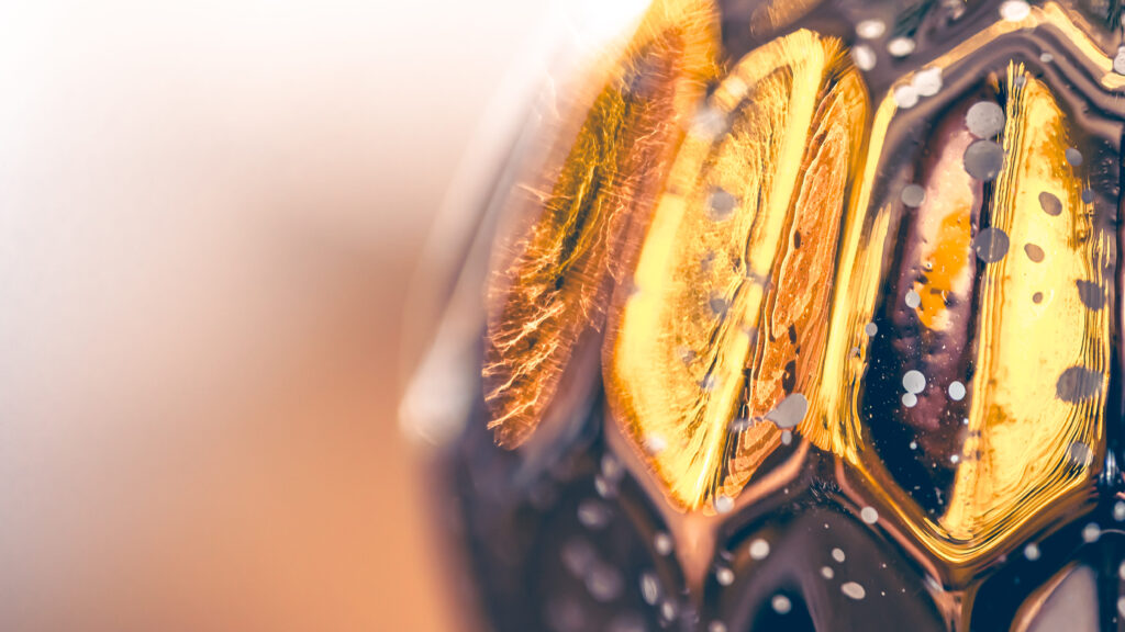 Makroaufnahme einer Weihnachtskugel in goltönen